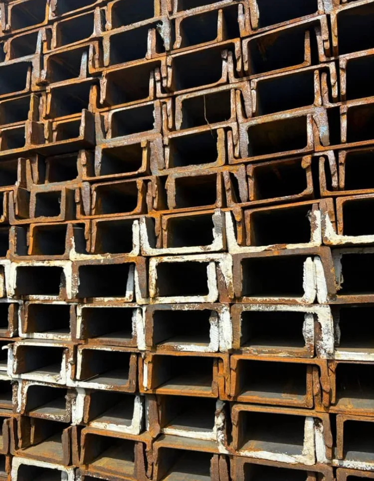 Close-up of weathered channel iron stacked at the yard.